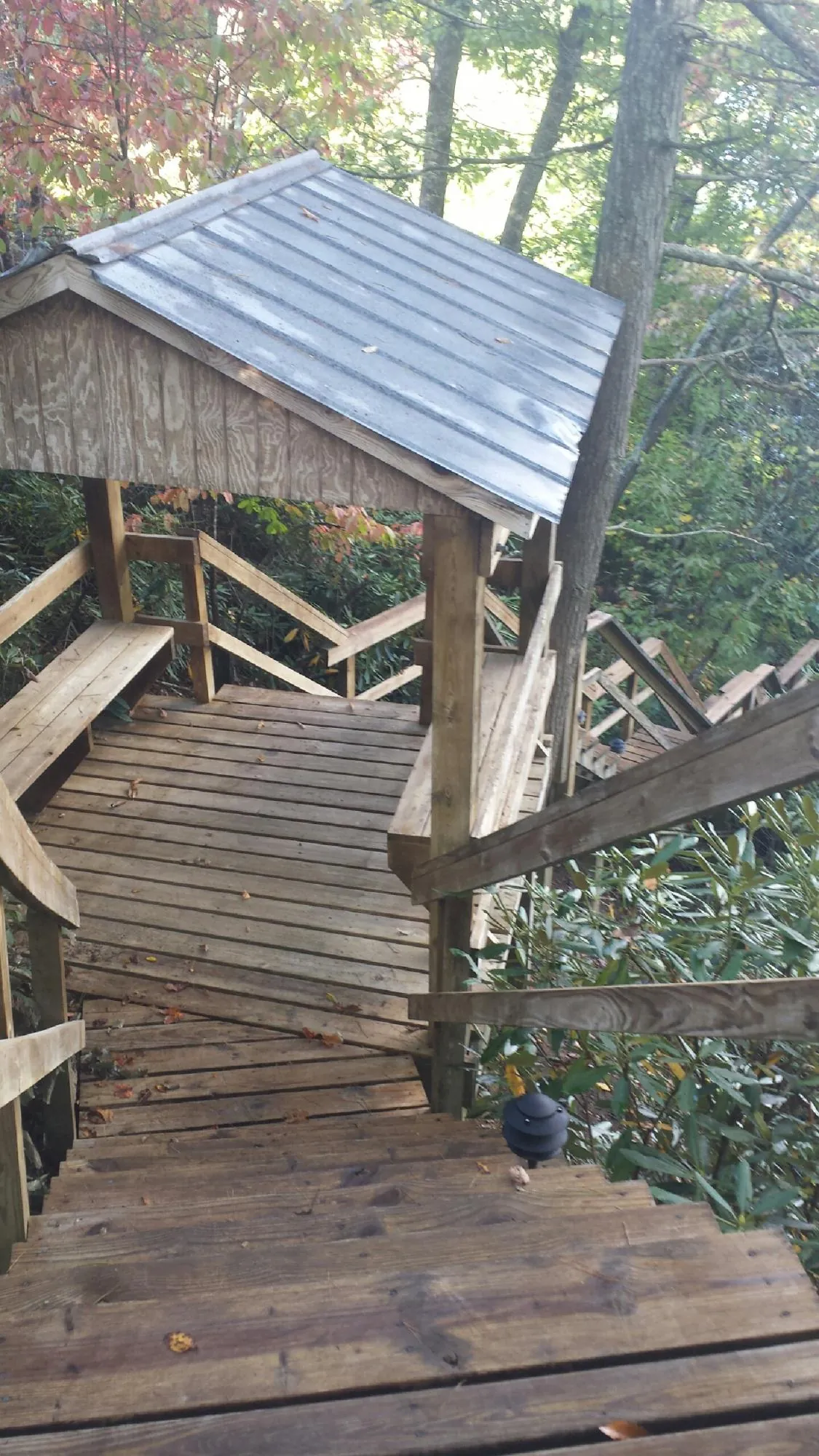 Metal roofed shelter over wooden steps on a wooded walkway — Skylight Repair & Installation work by our crew in Galway