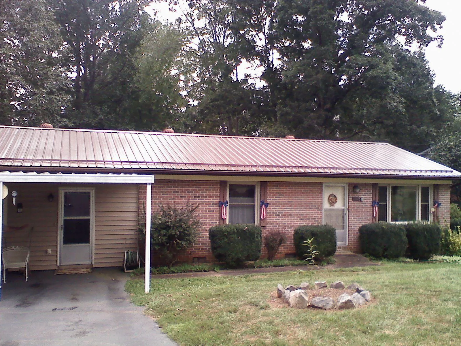Bronze metal roof and carport on a brick ranch home — Roof Repair work by our crew in Galway